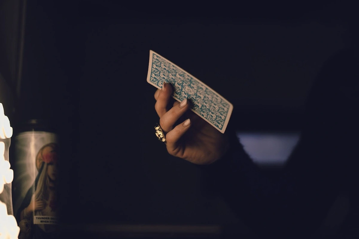 An image of a tarot card being dealt